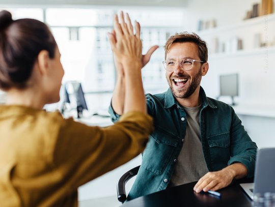 Arbeitskollegen freuen sich über Erfolg mit Handschlag