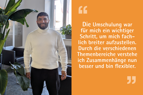 A smiling man stands in a bright room with plants. He is wearing a white turtleneck sweater and black pants. On the right side, there is a quote in German about the importance of retraining for broader professional development and understanding connections better.