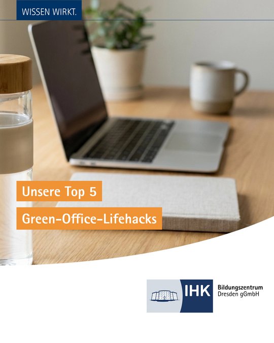 An image of a workspace featuring a laptop, a glass of water, and a cup. The text overlay reads “Unsere Top 5 Green-Office-Lifehacks” in orange and includes a logo in the corner. The background is softly blurred with some greenery visible.