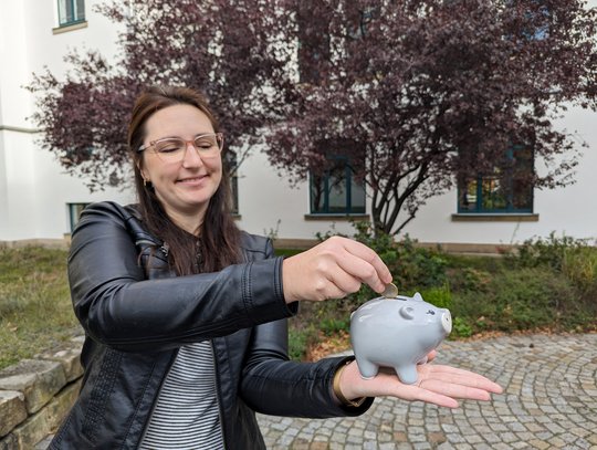 Frau füttert Sparschwein