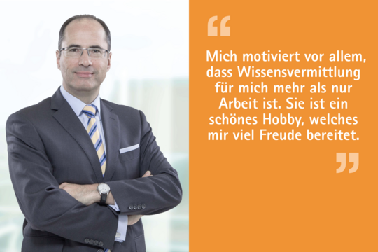 Ein Mann in einem Anzug steht mit verschränkten Armen vor einem hellen Hintergrund. Neben ihm steht ein Zitat: "Mich motiviert vor allem, dass Wissensvermittlung für mich mehr als nur Arbeit ist. Sie ist ein schönes Hobby, welches mir viel Freude bereitet."
